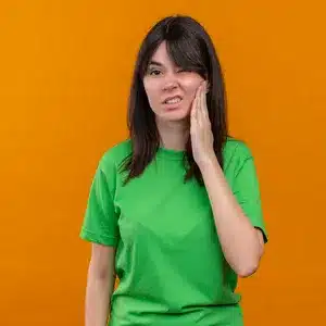 joven camiseta verde sostiene la cara